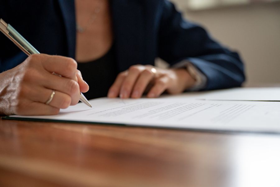 mujer firmando un documento